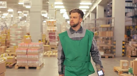 The worker is to a large warehouse with a terminal in the hand Stock Footage 64415207
