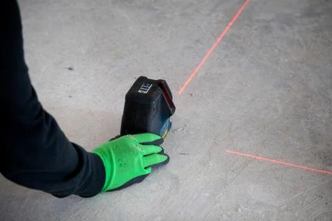Worker with laser rangefinder device on construction site. 스톡 사진