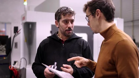 Worker with a lather consulting about problem to an engineer Stock Footage 258706566