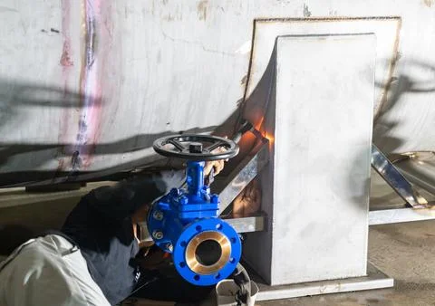 Worker lay down welding steam tank. Foto stock