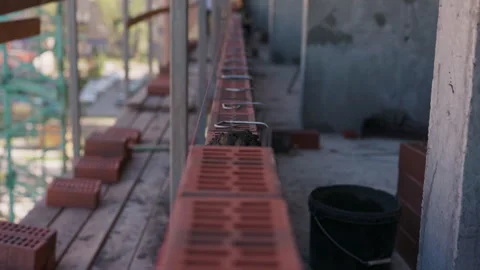 Worker laying brick on masonry wall during construction Vidéo 347215472
