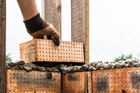 A worker is laying a brick wall. Stock Photos