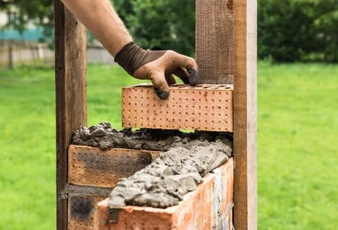 A worker is laying a brick wall. Stock Photos