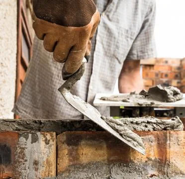 A worker is laying a brick wall. Stock Photos