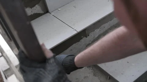 Worker laying ceramic tiles on staircase steps Stock Footage 314235759