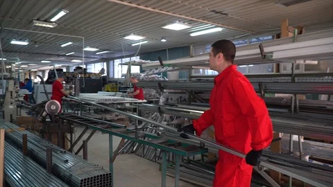 Worker laying down profile for cutting. A worker cuts a profile for plastic wind Stock Footage 100879915