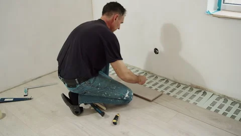 Worker Laying Foam Underlayment Sheets on Floor Stock Footage 322055240