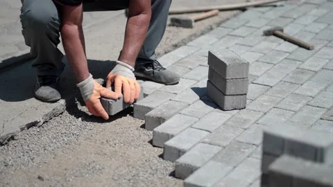 Worker laying gray concrete paving slabs on pavement, slow motion Video stock 227440326