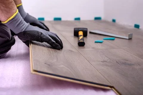 Worker laying laminate floor Stock Photos