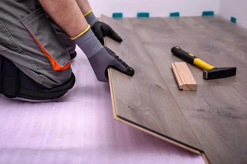 Worker laying laminate floor Stock Photos