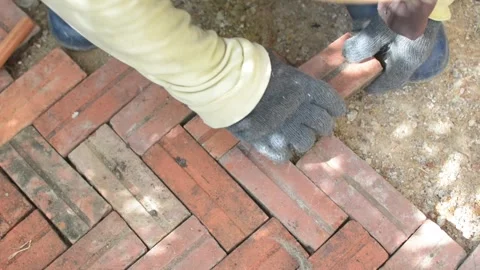Worker laying red brick  pathway around the house Stock Footage 255349982