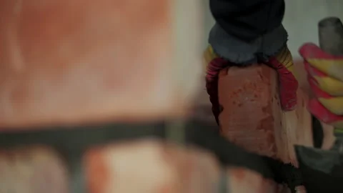 Worker Laying Red Bricks with Mortar in Masonry Wall Stock Footage 317396682
