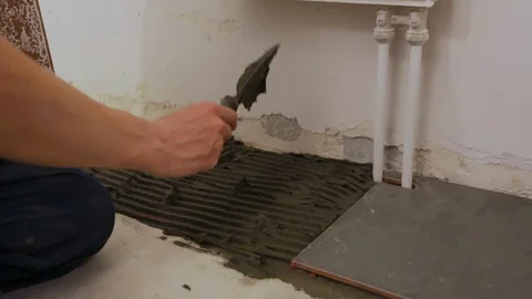 Worker laying tiles on floor Stock Footage 128414540