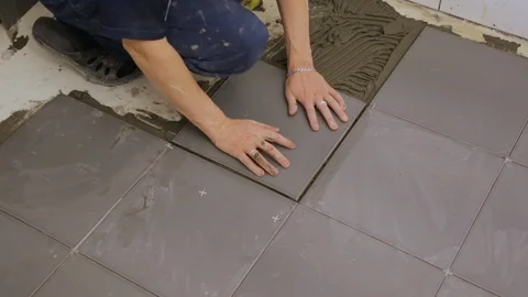 Worker laying tiles on floor Video stock 128416149