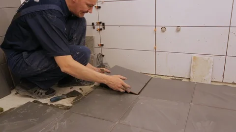 Worker laying tiles on floor Stock Footage 128416185