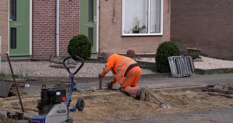Worker laying tiles at sidewalk of Netherlands street Stock Footage 95633448