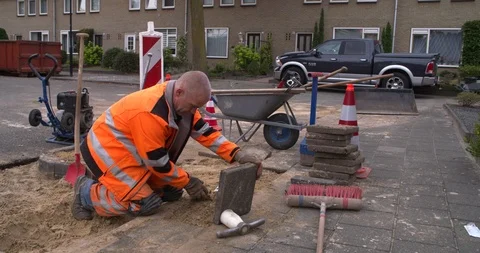 Worker laying tiles at sidewalk of Netherlands street Stock Footage 95643160