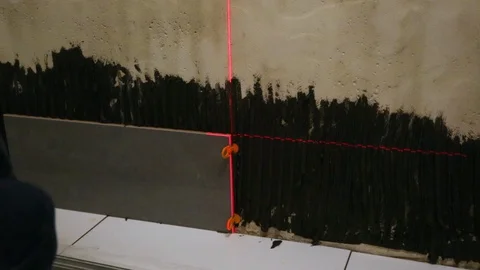 Worker laying tiles on the wall Video stock 128411083