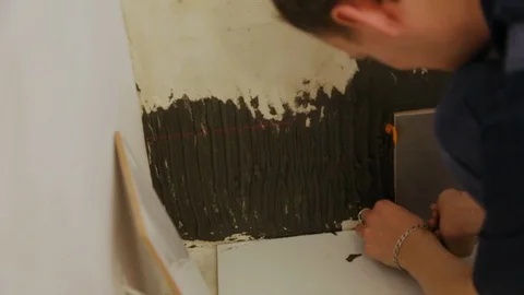 Worker laying tiles on the wall Stock Footage 128412158