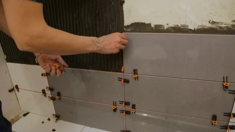 Worker laying tiles on the wall Stock Footage 128412296