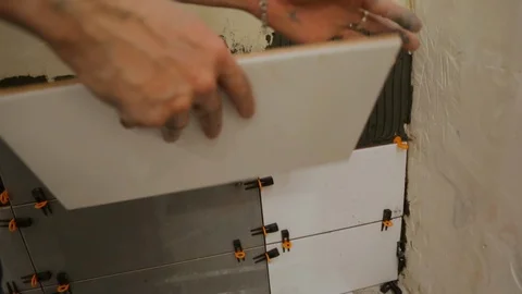 Worker laying tiles on the wall Stock Footage 128412335