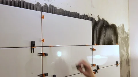 Worker laying tiles on the wall Stock Footage 128413246