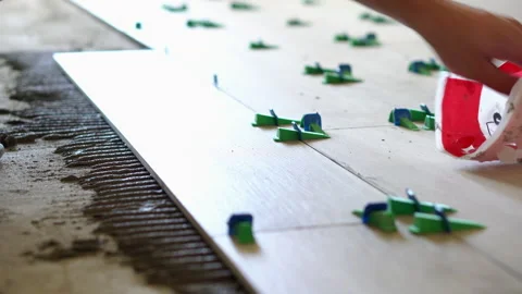 A worker lays ceramic tiles on the floor in an apartment Video stock 250279072