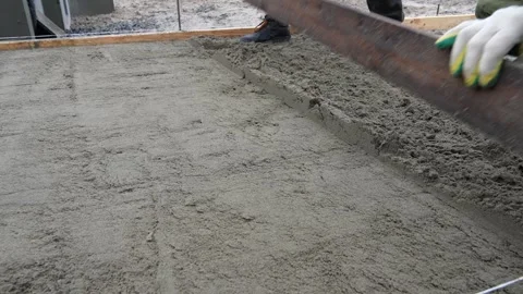 A worker lays down sand for paving slabs. Construction Stock Footage 330343147