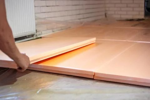 Worker lays polystyrene foam on the floor. Insulation of the house, install.. Stock Photos