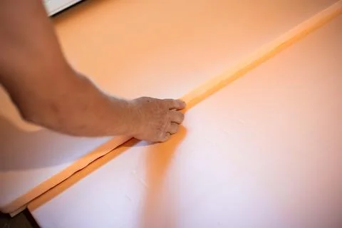 Worker lays polystyrene foam on the floor. Insulation of the house, install.. Stock Photos
