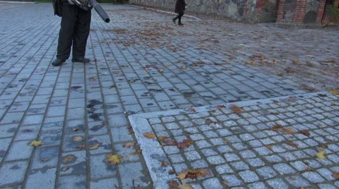 Worker  with leaf blowers clean up autumn leaves from street Stock Footage 46803543