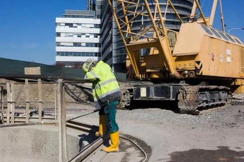 Worker leaning over a railing of a deep shaft Stock Photos
