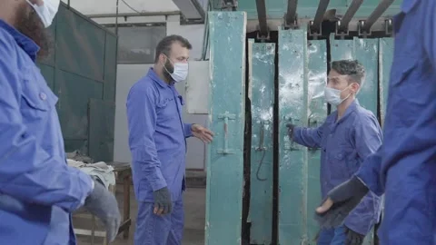 Worker of a leather factory changing metal net to work with skin leather, Stock Footage 292603085