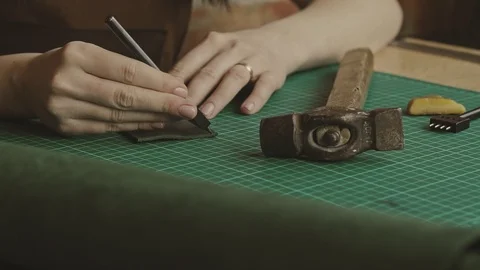 Worker of leather makes holes. Process of manufacturing leather wallet Stock Footage 116432862