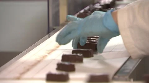 Worker leveled on the conveyor chocolates Stock Footage 94873375