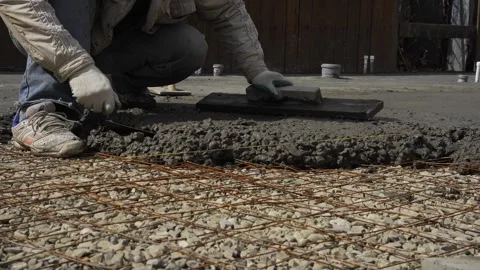 A worker leveling cement with a spatula Stock Footage 307384349