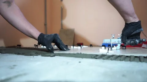 A worker is leveling the ceramic tile with wedges and clips. Stock-Footage 152241544
