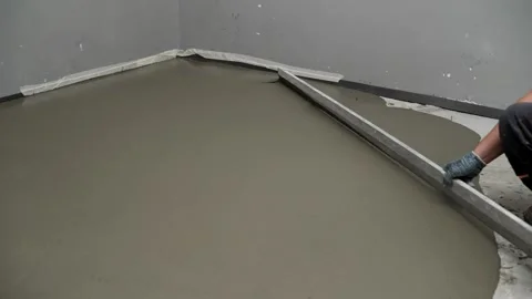 Worker Leveling Concrete Floor With Tool Stock Footage 335296114