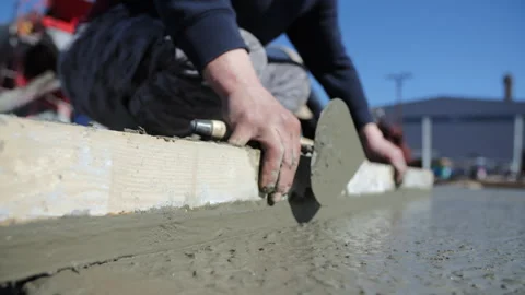 Worker leveling freshly poured concrete with trowel Stock Footage 306460306