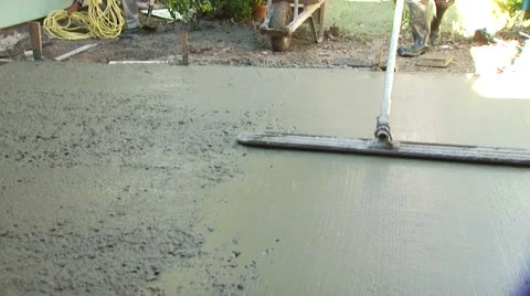 Worker leveling mixture of cement with concrete rake Stock Footage 55570528