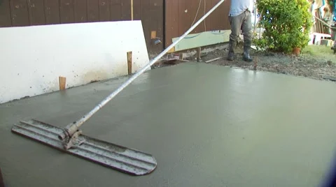 Worker leveling mixture of cement with concrete rake Stock Footage 55570533