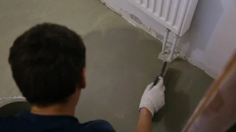 Worker leveling mortar on floor Video stock 128410676