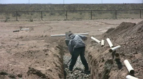 Worker Leveling Out Stones in Drainfield for Septic Stock Footage 548227