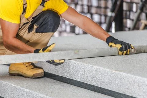 Worker Leveling Stone Slabs in Construction Site Foto stock