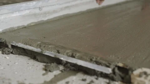 The worker is leveling the surface. Leveling the floor with a screed in the room Stock-Footage 247207818