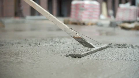 Worker leveling wet concrete floor with screed tool Stock Footage 326064684