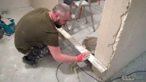 A worker levels the plaster at the doorway Stock Footage 169624980