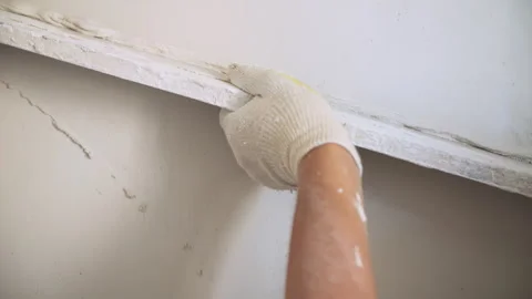 A worker levels the wall in the apartment with putty Stock Footage 285537262