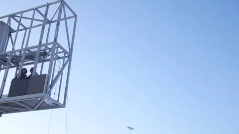Worker in lift bucket during installation big billboard in bad weather. Workers Stock Footage 84743336