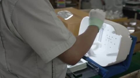 Worker lifting and visually inspecting white rice cooker outer lid with handle Vidéo 334966535